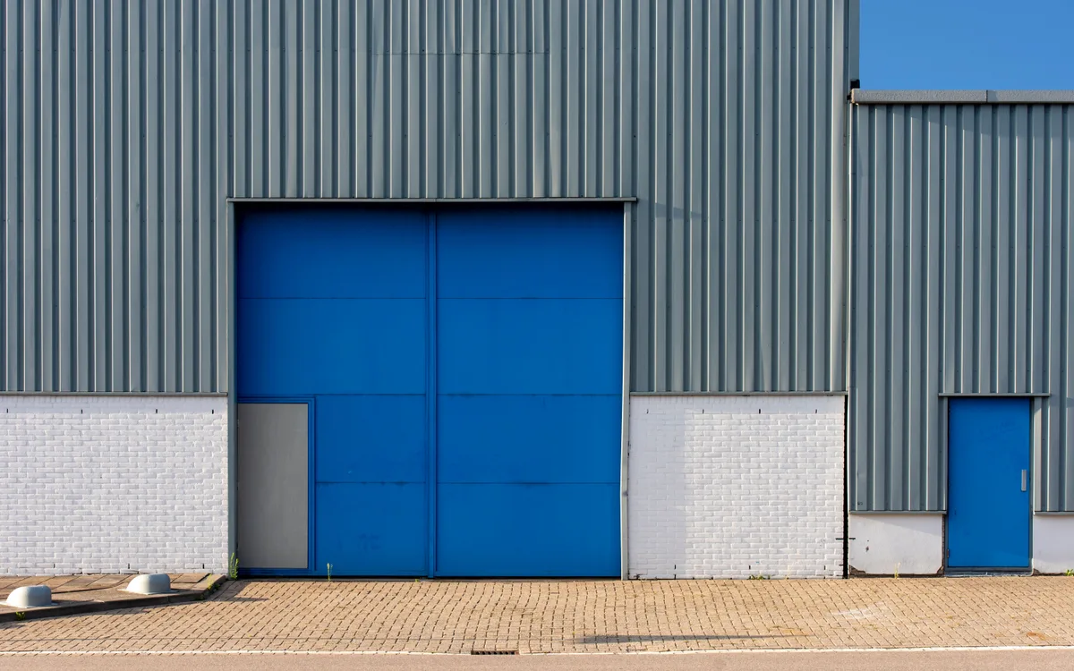Acceso a una bodega de almacenamiento con portón azul